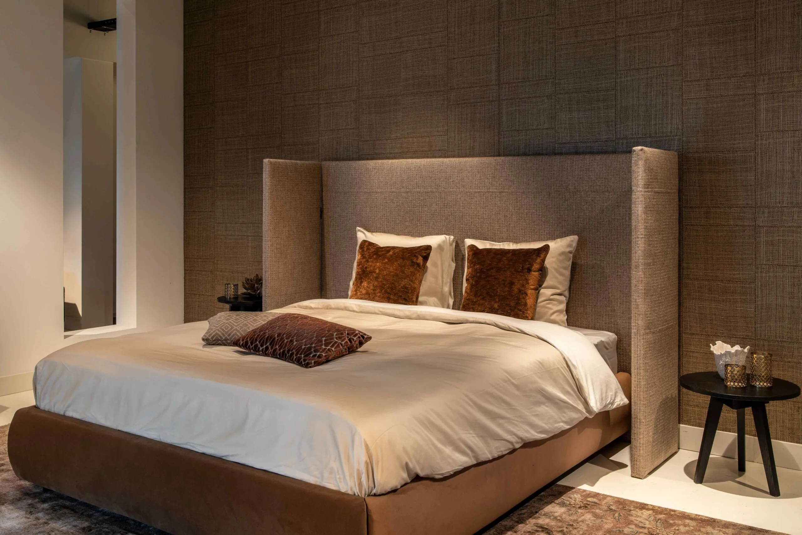 a brown sofa with a plaid and a pillow on the background of a bookcase