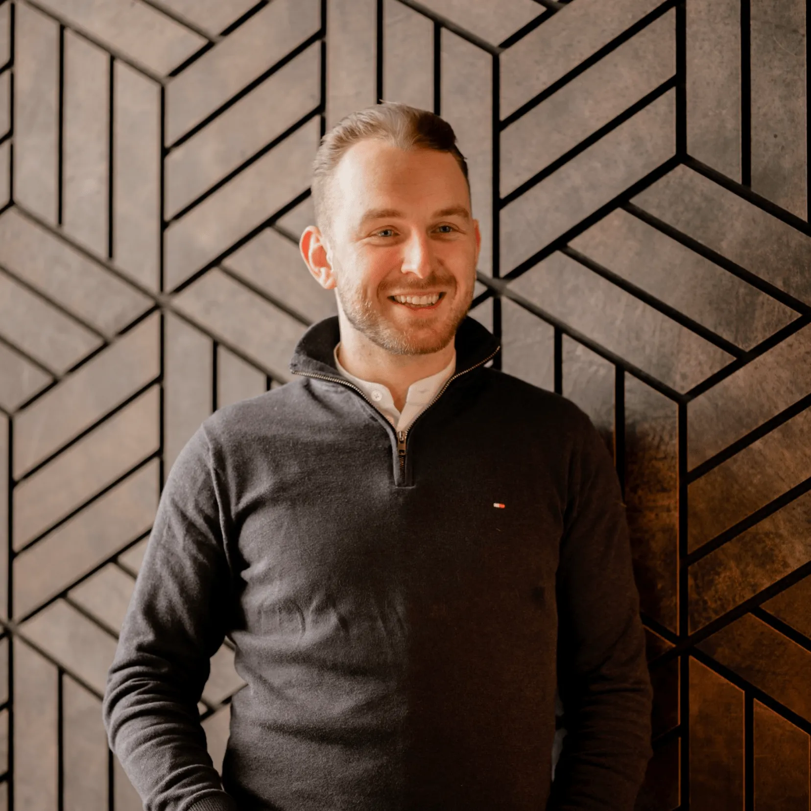 a brown sofa with a plaid and a pillow on the background of a bookcase